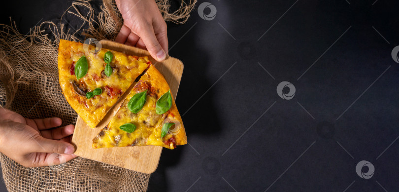 Скачать Кусок запеченной пиццы с грибами и базиликом, помидорами и сыром, черный фон, плоская выкладка, место для копирования фотосток Ozero