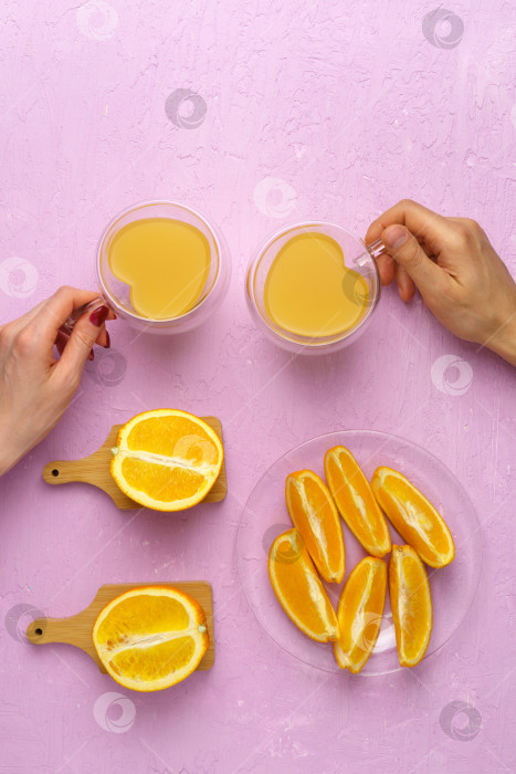 Скачать Свежевыжатый апельсиновый сок в стакане и апельсины на розовом фоне. Вид сверху, вертикальная фотография фотосток Ozero
