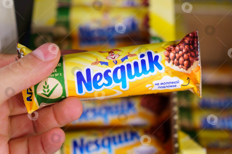 Скачать Тюмень, Россия - 13 апреля 2022 года: Плитка шоколада nesquik в руках покупателя. Избирательный фокус фотосток Ozero