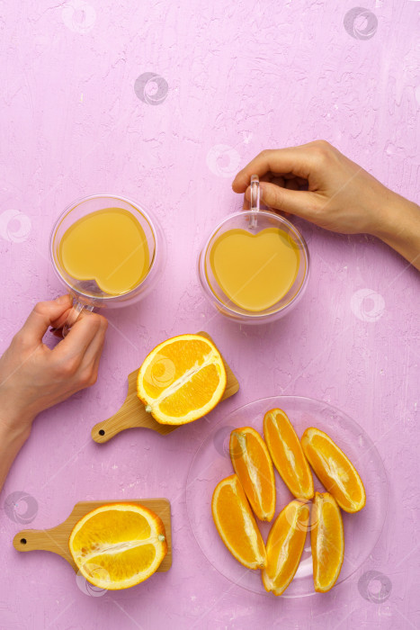 Скачать Апельсиновый сок апельсин на розовом фоне. Приготовление апельсинового сока для здоровья. Плоская поверхность фотосток Ozero