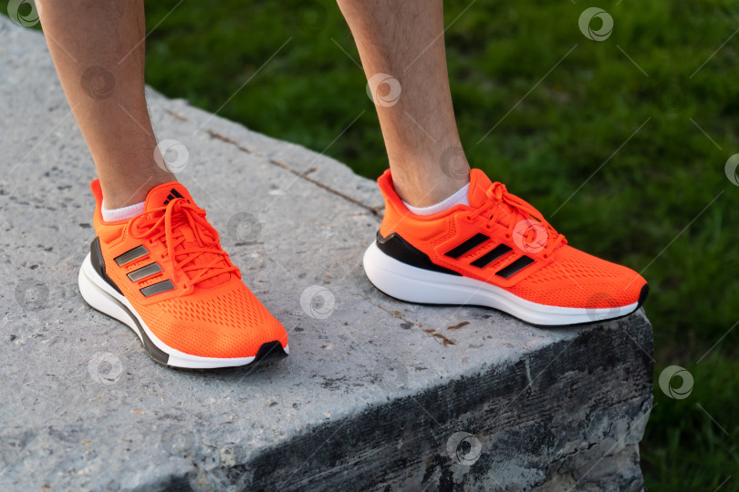 Скачать Тюмень, Россия- 03 мая 2022 года: Мужские кроссовки Adidas orange - немецкая корпорация, которая разрабатывает и производит спортивную обувь, одежду и аксессуары фотосток Ozero