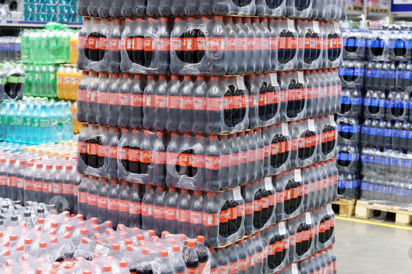 Скачать Тюмень, Россия - 11 мая 2022 года: Пластиковые бутылки Coca-Cola в супермаркете. Coca-Cola - это газированный безалкогольный напиток, производимый компанией Coca-Cola Company фотосток Ozero