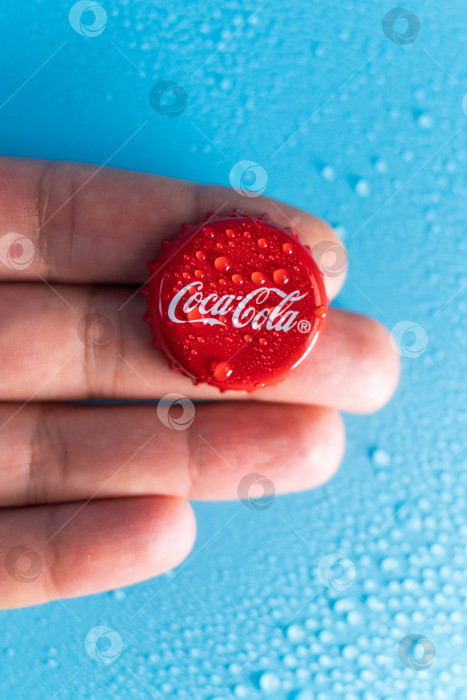 Скачать Тюмень, Россия - 19 января 2022 года: Красная крышка стеклянной бутылки Coca-Cola. Капли воды вертикальное фото фотосток Ozero