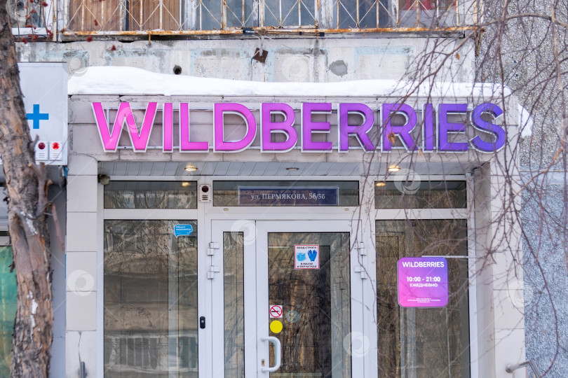 Скачать Тюмень, Россия - 22 февраля 2022 года: вывеска Wildberries на фасаде здания ночью, крупнейшего российского онлайн-ритейлера. фотосток Ozero