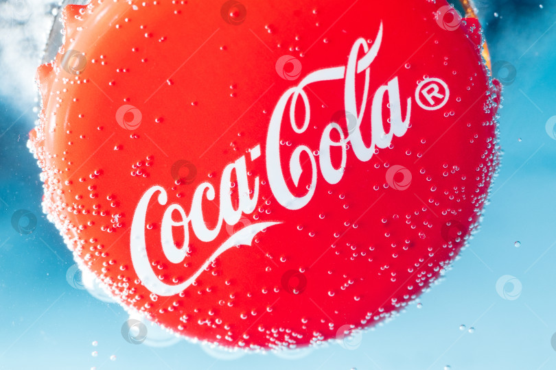 Скачать Тюмень, Россия - 19 января 2022 года: Логотип Coca-Cola на крышке крупным планом с каплями воды. Избирательный фокус. фотосток Ozero