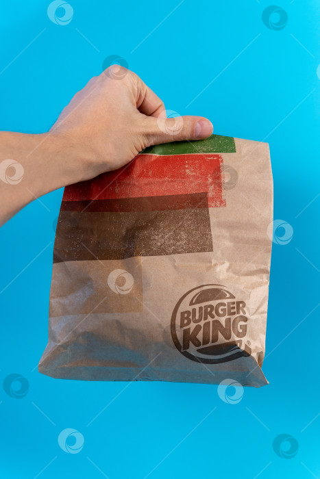 Скачать Тюмень, Россия - 23 января 2022 года: Бумажный пакет с логотипом Burger King. Burger King - это глобальная сеть ресторанов быстрого питания с гамбургерами. Вертикальная фотография фотосток Ozero