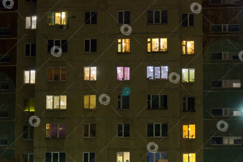 Скачать Ночные окна многоэтажного здания. Светящиеся и темные окна в жилом здании фотосток Ozero