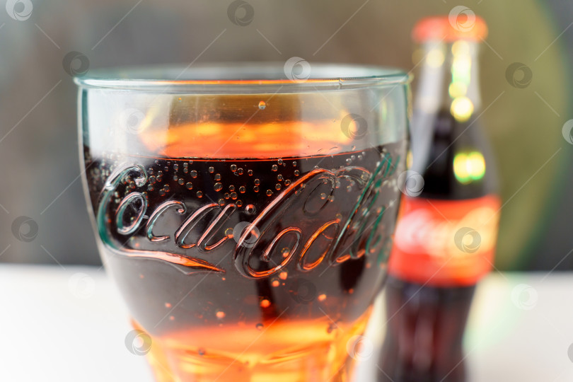 Скачать Тюмень, Россия - 02 ноября 2022 года: логотип Coca-Cola в стакане крупным планом. Американская многонациональная компания по производству напитков Coca-Cola. Избирательный фокус фотосток Ozero