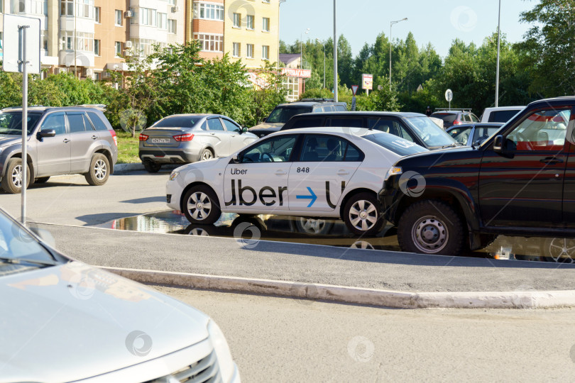 Скачать Тюмень, Россия - 09 июля 2022 года: автомобиль такси с логотипом Uber. Uber - американская компания, предлагающая транспортные услуги онлайн. фотосток Ozero