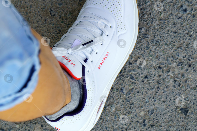 Скачать Тюмень, Россия - 27 апреля 2022 года: логотип компании Skechers на белых кроссовках. Skechers USA, Inc. - это американский стиль жизни. Избирательный фокус фотосток Ozero