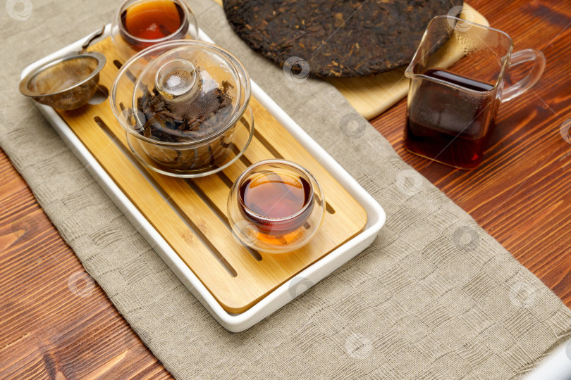 Скачать Китайская чайная церемония прессованного пуэра на деревянном столе "Утренняя энергия". Избирательный фокус фотосток Ozero