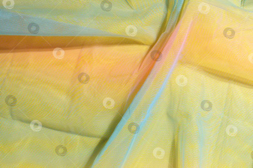 Скачать Желтый тканевый фон. Шелковая ткань переливающихся цветов создает складки. Разноцветный текстиль. Текстура фотосток Ozero