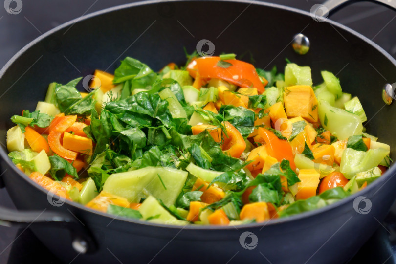 Скачать Готовим овощное рагу с перцем, морковью, цуккини и сельдереем. Перетасовки крупным планом. Домашняя вегетарианская еда фотосток Ozero