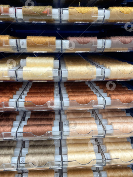 Скачать Разноцветный фон из швейных ниток. Разноцветные катушки для ниток, используемые в тканевой и текстильной промышленности. Вертикальная фотография фотосток Ozero