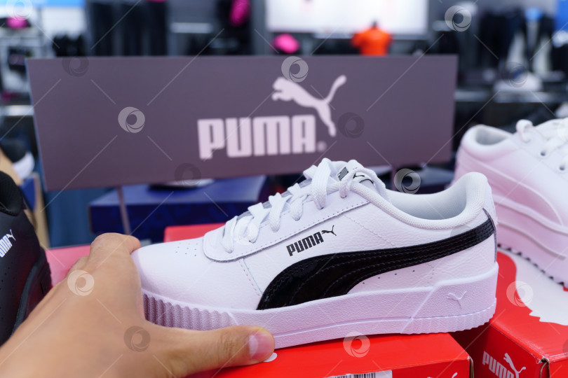 Скачать Тюмень, Россия - 12 августа 2022 года: Белые кроссовки от Puma в демонстрационном зале магазина спортивной одежды. Концепция спортивной и повседневной обуви фотосток Ozero