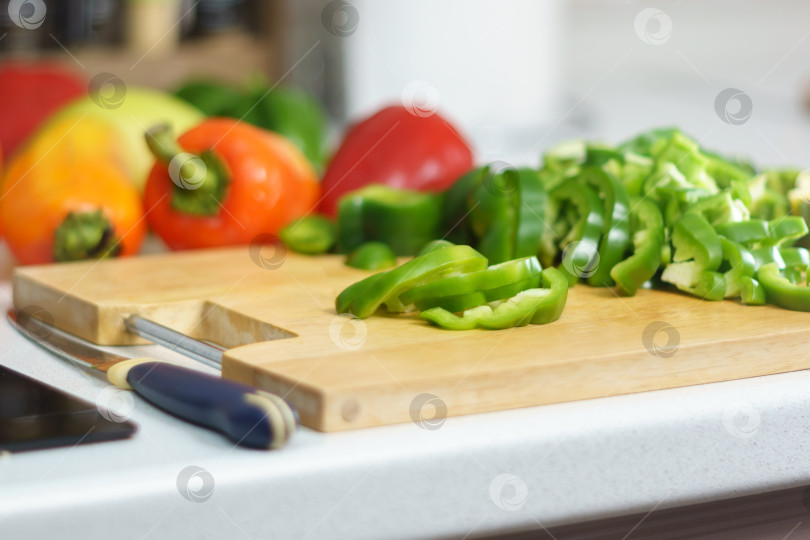 Скачать Нарезка зеленого болгарского перца, кулинария, концепция еды и дома. Разделочная доска в домашних условиях фотосток Ozero