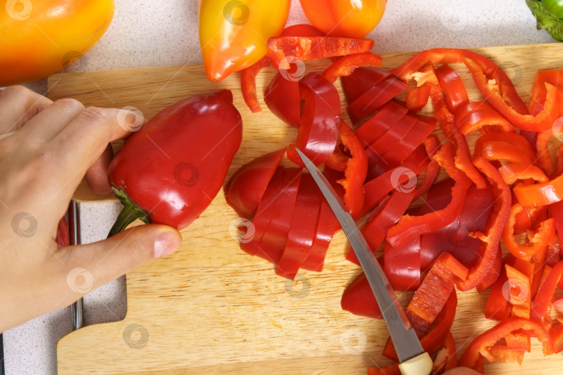 Скачать Нарезанный ломтиками красный перец, который добавляют в пищу для придания вкуса блюду фотосток Ozero