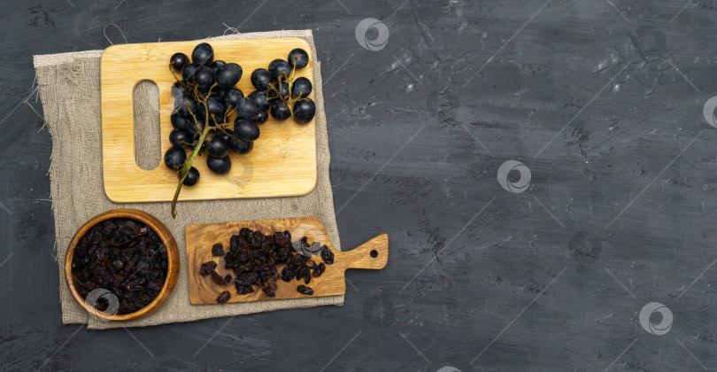 Скачать Сушеный черный изюм в деревянной ложке со свежим спелым виноградом. Полезная закуска, диетический продукт. Пространство для копирования фотосток Ozero