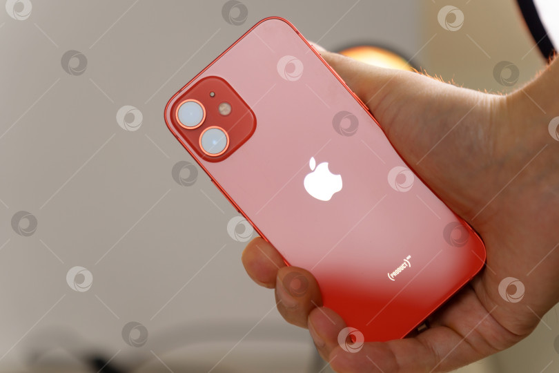 Скачать Тюмень, Россия- 12 августа 2022 г.: iPhone 12 mini красного цвета с розничной коробкой, концептуальное фото покупки, желтый фон фотосток Ozero