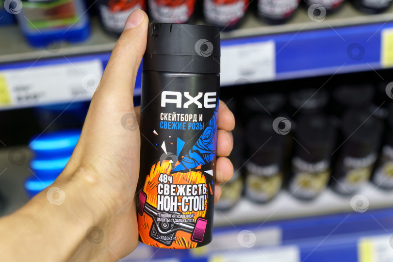 Скачать Тюмень, Россия - 30 июня 2022 года: Спрей-дезодорант Axe skateboard и свежие розы на полках гипермаркета. Местный универмаг. фотосток Ozero