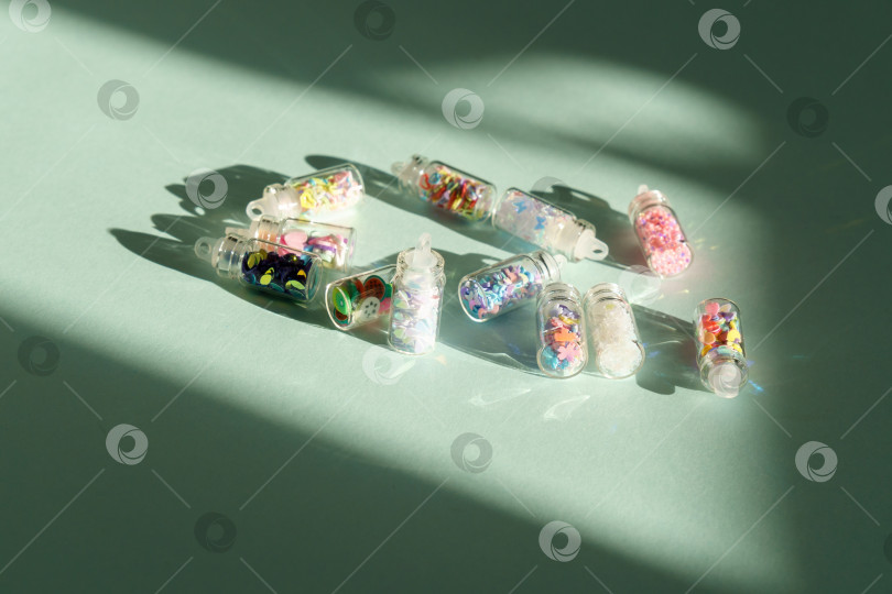 Скачать Цветные флакончики для маникюра с блестками изготовлены из пластика. Концепция красоты и ногтей. Избирательный фокус фотосток Ozero