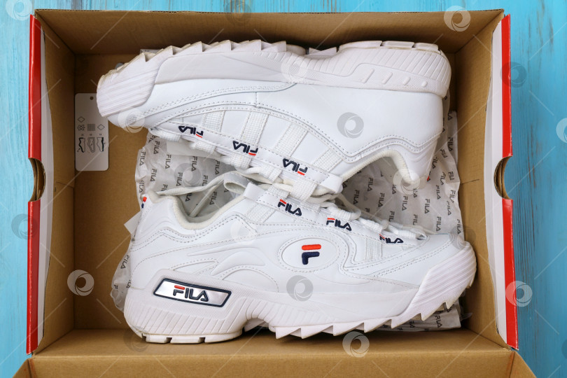 Скачать Тюмень, Россия - 12 августа 2022 года: логотип белых кроссовок Fila на одежде в спортивном магазине. Концепция спортивной и повседневной обуви фотосток Ozero