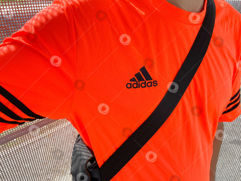 Скачать Тюмень, Россия - 30 августа 2022 года: логотип Adidas на мужской футболке. Adidas - немецкий дизайнер и производитель спортивной одежды и аксессуаров фотосток Ozero