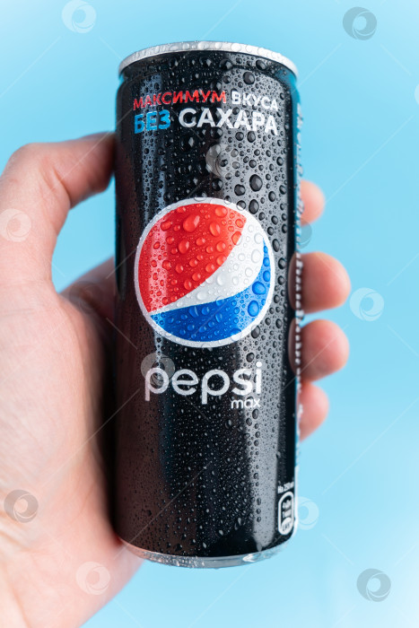 Скачать Тюмень, Россия - 19 января 2022 года: Логотип Pepsi in hand - газированный безалкогольный напиток производства PepsiCo. Вертикальная фотография фотосток Ozero