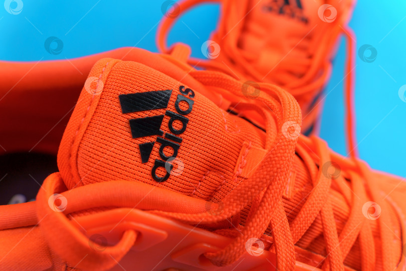 Скачать Тюмень, Россия - 13 ноября 2021 года: логотип Adidas на оранжевых кроссовках крупным планом. Избирательный фокус фотосток Ozero