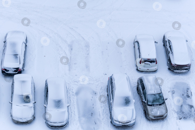 Скачать Место для парковки на подъездной дорожке к городской улице с небольшим автомобилем, покрытым снегом. Экстремальные погодные условия. Избирательный фокус фотосток Ozero