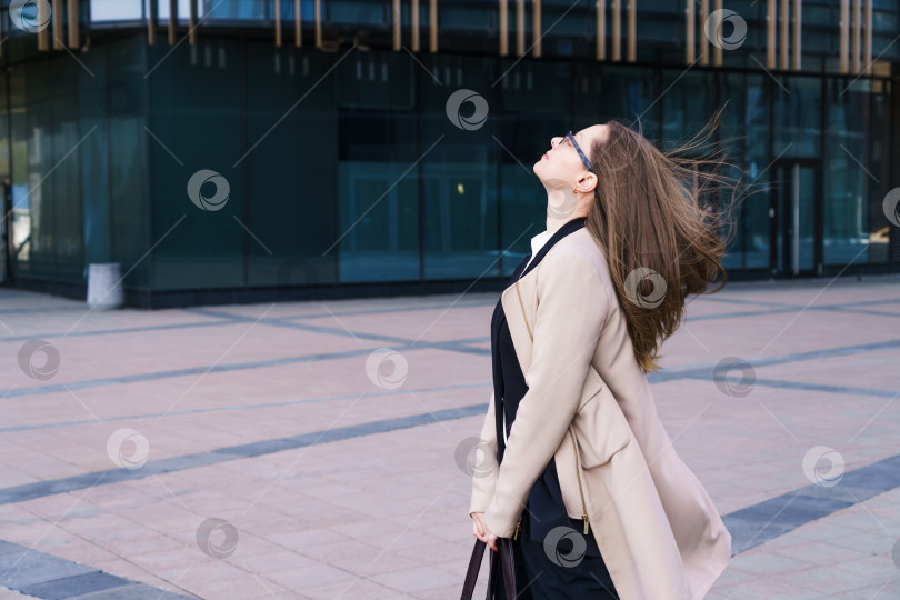 Скачать Деловая женщина с задумчивым взглядом в очках в бизнес-центре фотосток Ozero