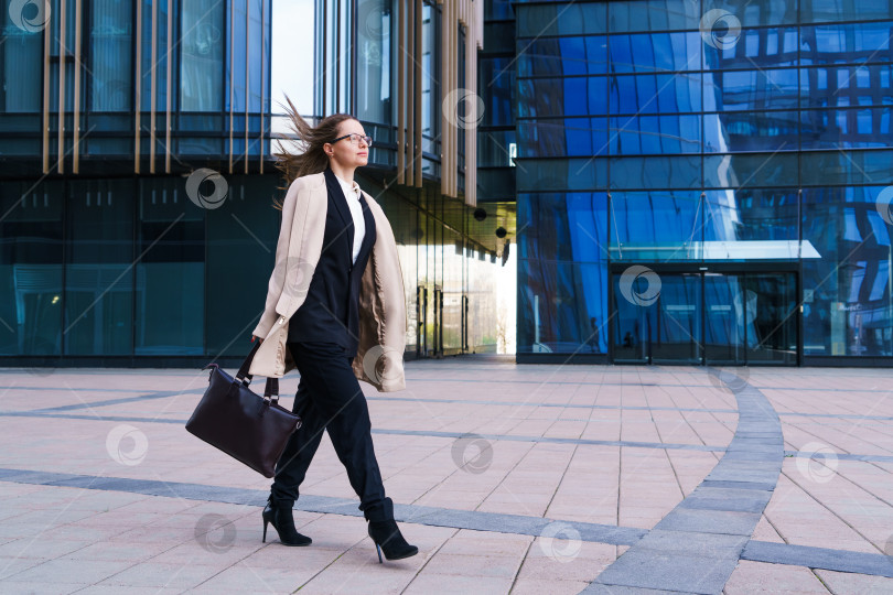 Скачать Успешная счастливая деловая женщина с сумкой на фоне офисного здания фотосток Ozero