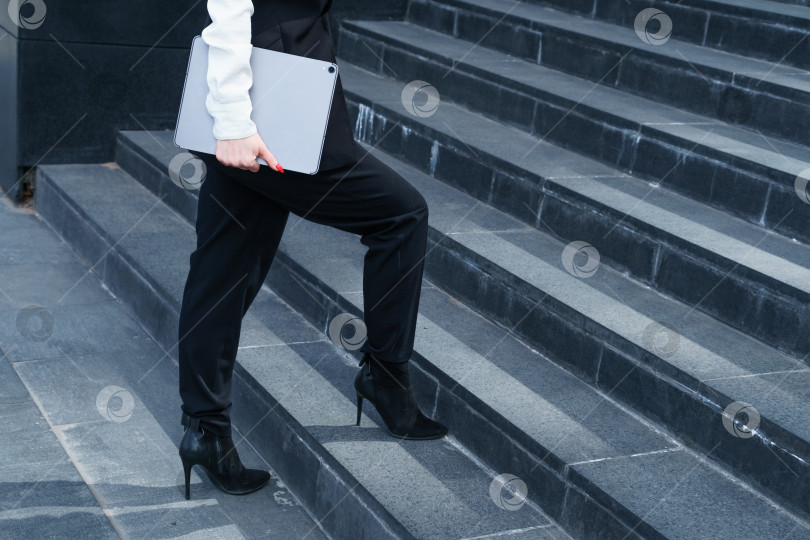 Скачать Женщина-генеральный директор разговаривает по смартфону, или секретарша идет на работу, поднимается по лестнице. фотосток Ozero