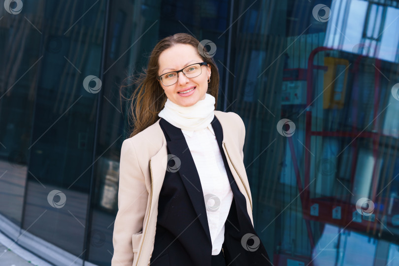 Скачать Портрет счастливой успешной женщины в очках на фоне офисного здания фотосток Ozero