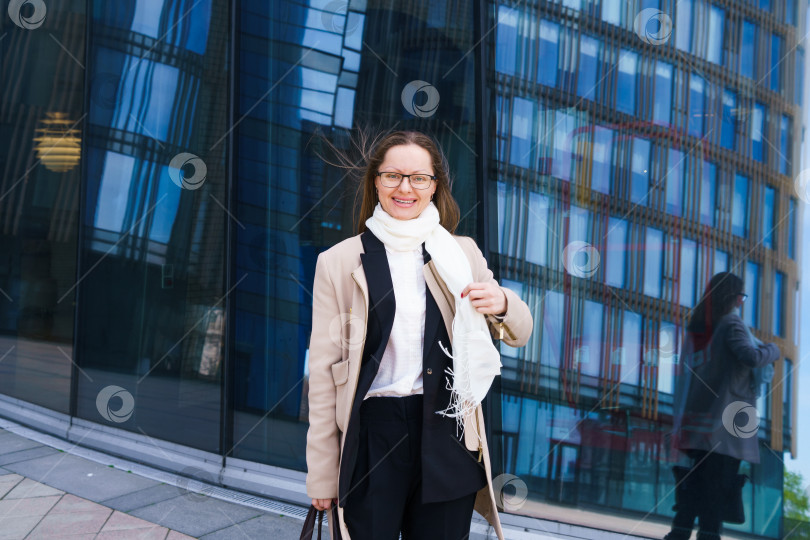 Скачать Успешная счастливая деловая женщина с сумкой на фоне офисного здания фотосток Ozero