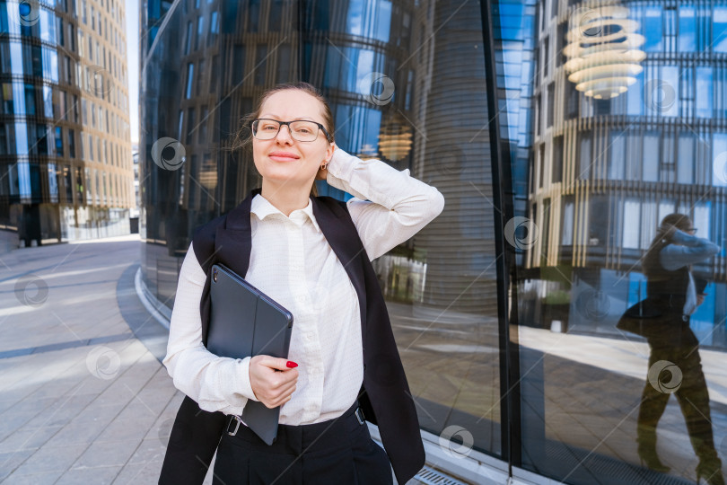 Скачать Успешная профессиональная женщина перед стеклянным зданием с ноутбуком в руках фотосток Ozero