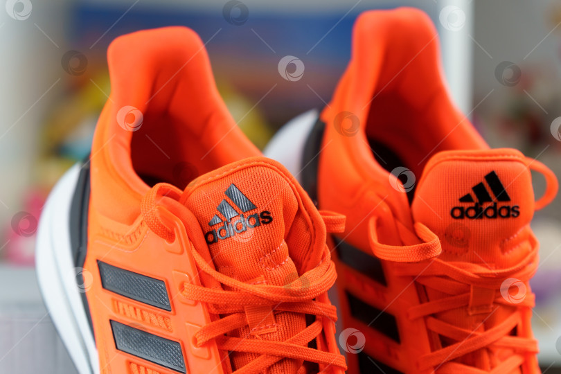 Скачать Тюмень, Россия - 13 ноября 2021 года: логотип Adidas на оранжевых кроссовках крупным планом. Избирательный фокус фотосток Ozero