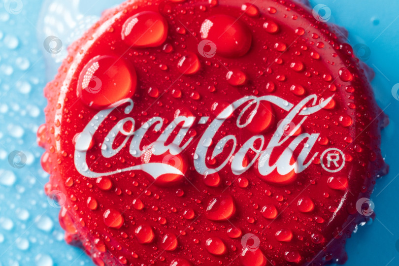Скачать Тюмень, Россия - 19 января 2022 года: Красная крышка стеклянной бутылки Coca-Cola. Капли воды крупным планом фотосток Ozero