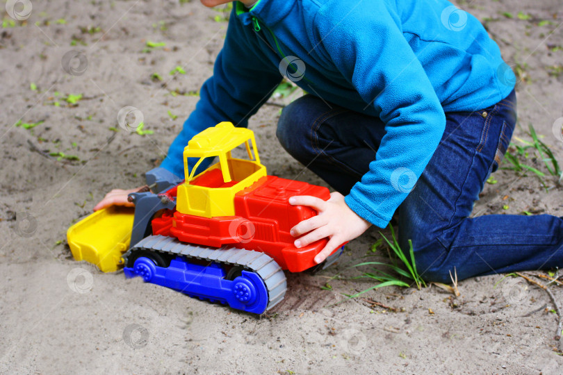 Скачать Ребенок играет на песке с игрушечной машинкой. фотосток Ozero