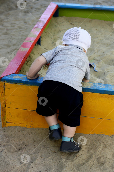 Скачать Ребенок, играющий в песочнице. фотосток Ozero
