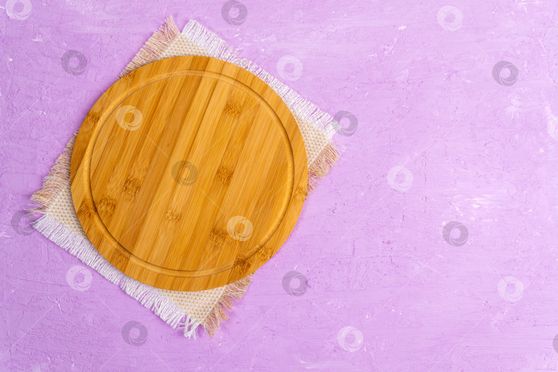Скачать Пустая деревянная тарелка на бетонном столе. Деревянная тарелка для еды. Лежал плашмя. Фиолетовый фон фотосток Ozero
