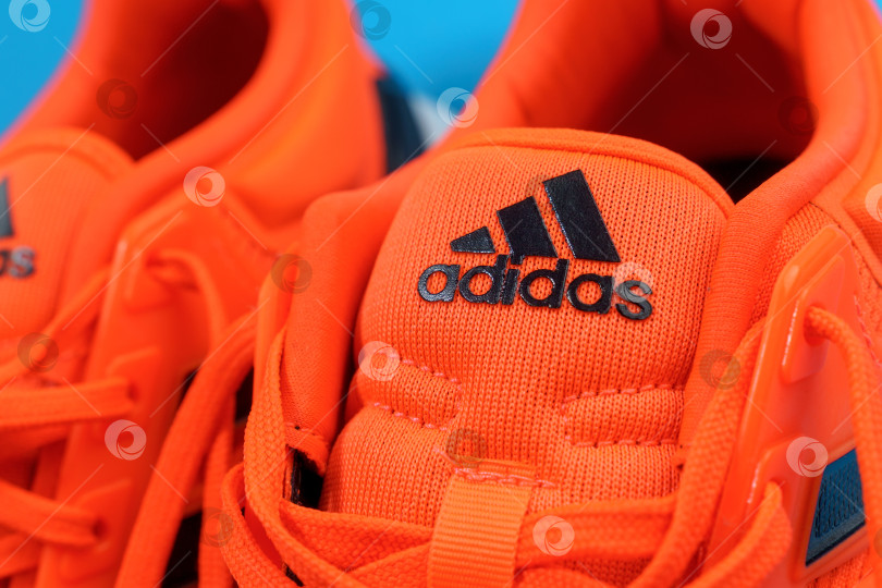 Скачать Тюмень, Россия - 13 ноября 2021 года: логотип Adidas на оранжевых кроссовках крупным планом. Избирательный фокус фотосток Ozero