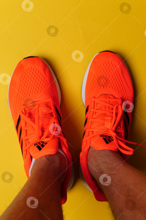 Скачать Тюмень, Россия - 13 ноября 2021 года: Новые кроссовки adidas оранжевого цвета. Вертикальная фотография фотосток Ozero