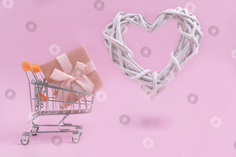 Скачать Покупаю подарки на День Святого Валентина на розовом фоне. Пространство для копирования фотосток Ozero