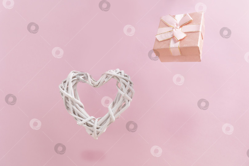 Скачать Подарочная коробка и белое сердечко на пастельно-розовом фоне. Концепция дня Святого Валентина. Плоская укладка, пространство для копирования фотосток Ozero