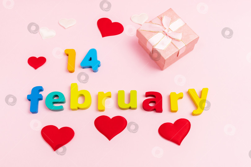Скачать День Святого Валентина на розовом фоне. Подарочная коробка с надписью 14 февраля. Вид сверху. Вертикальная фотография фотосток Ozero