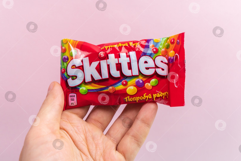 Скачать Тюмень, Россия - 27 декабря 2021 года: Оригинальные конфеты марки Skittles. Разноцветный фон. вкусные сладкие кегли фотосток Ozero