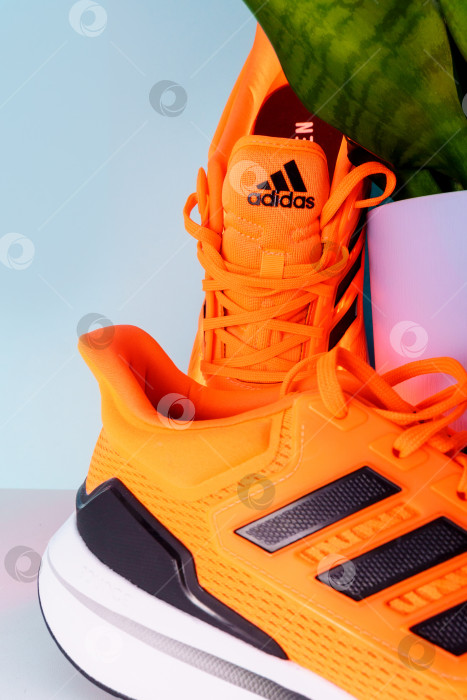 Скачать Тюмень, Россия - 13 января 2022 года: логотип Adidas на оранжевых кроссовках. Вертикальная фотография фотосток Ozero