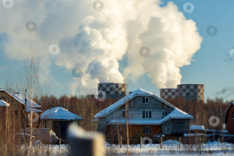 Скачать Пар из труб фабрики в зимнем городе. Мощная отопительная котельная зимой. Избирательный фокус фотосток Ozero