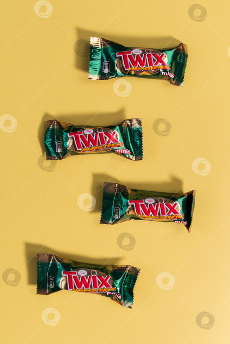 Скачать Тюмень, Россия - 23 января 2022 года: Мини-батончики Twix со вкусом имбирного печенья на желтом фоне. Вертикальная фотография фотосток Ozero